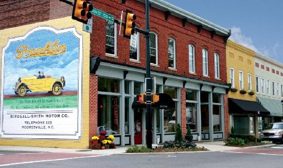 Mooresville, NC streetscape near downtown with local shops and trees.