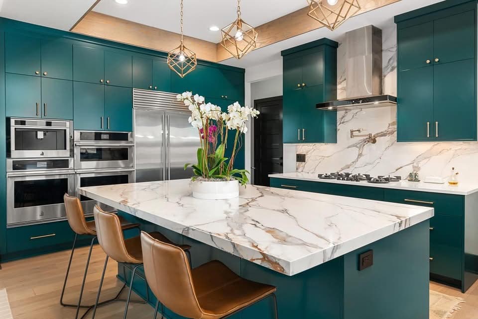 Quartz island with gray veining and teal cabinetry